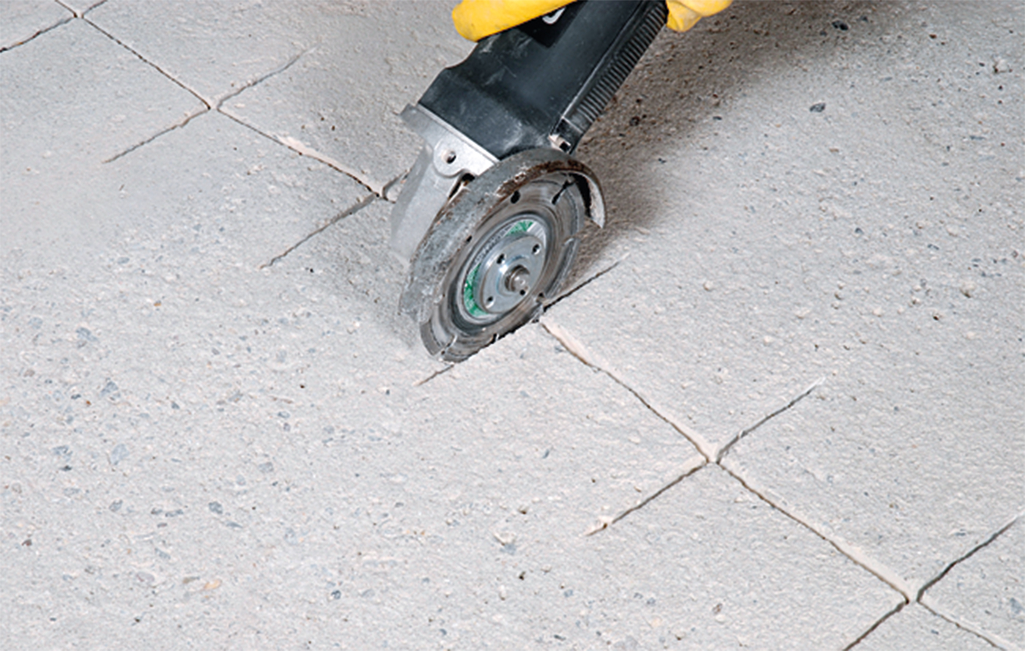 Aufschneiden und Verbreitern eines Estrichrisses mit einer Trennscheibe zur Vorbereitung der Sanierung.